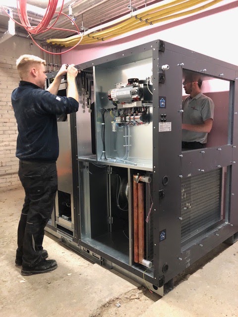Engineer working on an open outdoor air conditioning unit